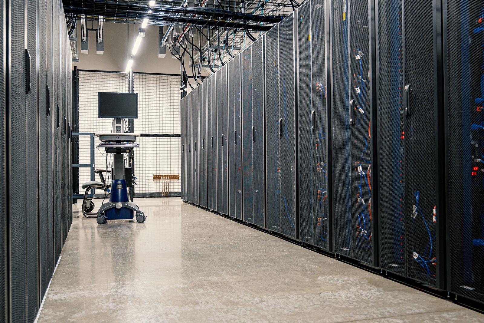Cold aisle of a data center lined with server racks